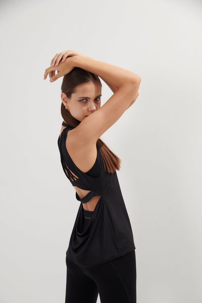 An easy and flattering fit that floats away from your body. With open back so you can show off your bra details. Also, it has beautiful drapes details at the back. Quick dry, light and comfortable on your skin. From all day, practicing to pacing you decide. It is a staple piece!